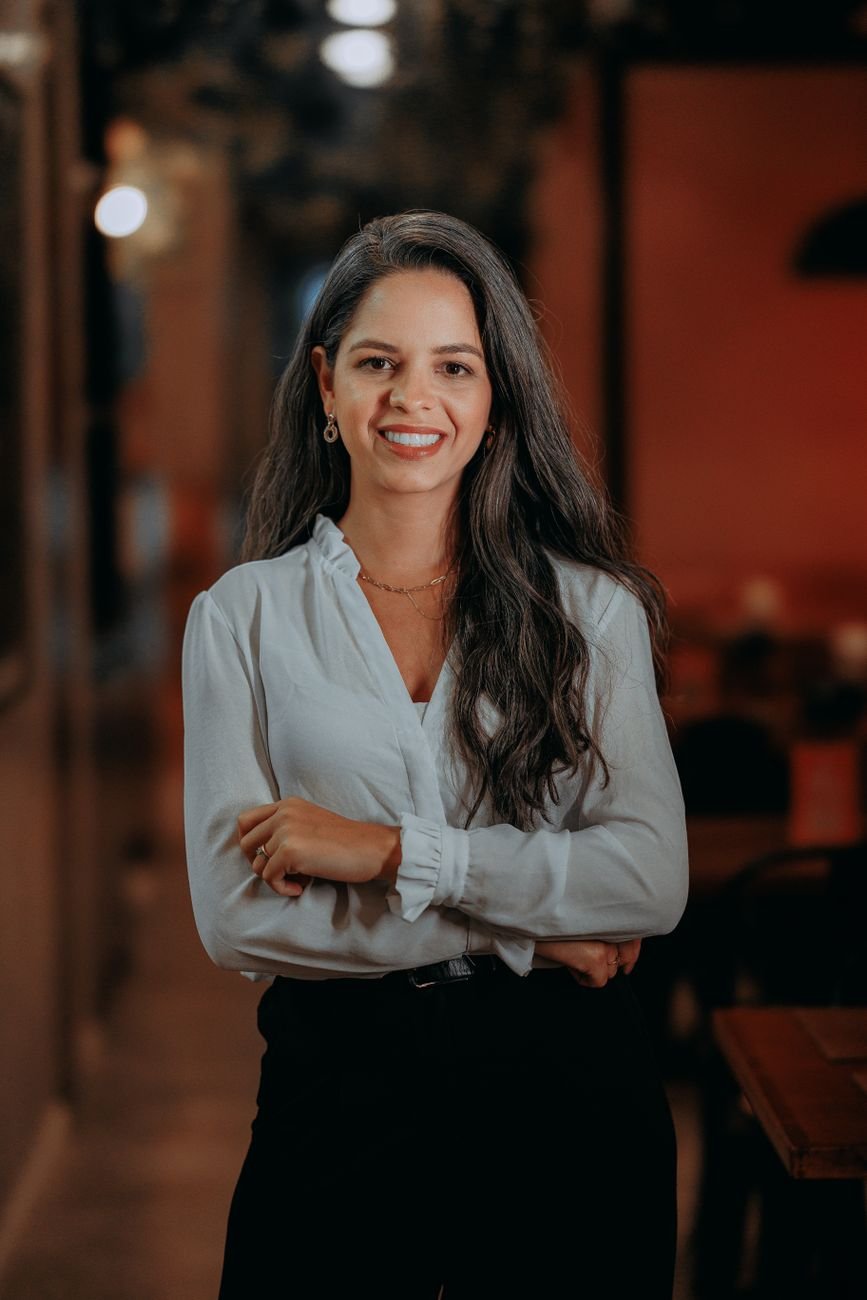 Portrait of a confident young woman smiling in an indoor setting. Bright and welcoming.